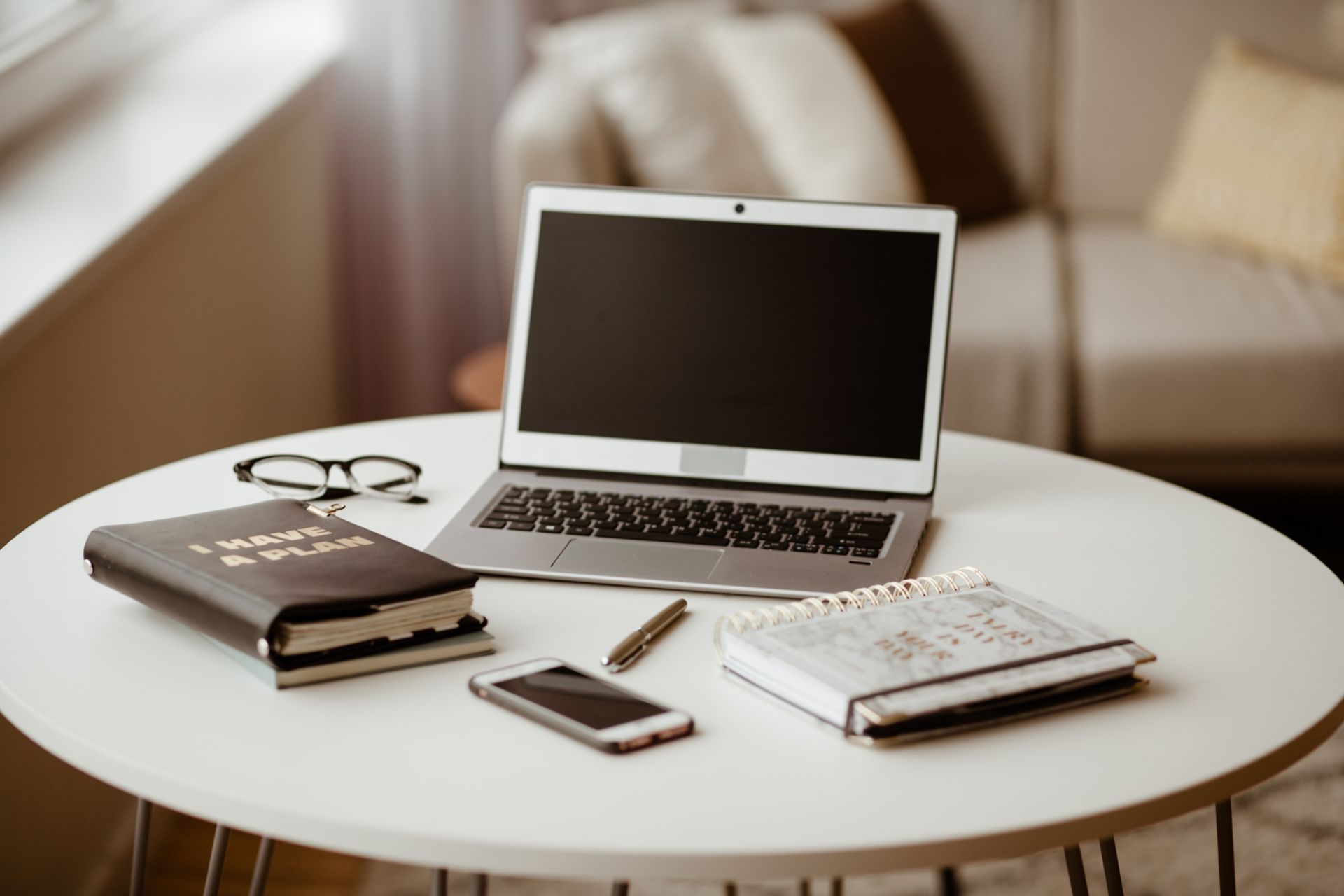 A laptop and planner on a work table
